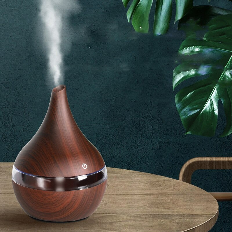 Dark wood ultrasonic desk diffuser with cool mist on a home-office desk